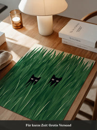 Schwarze Katzen im hohen Gras